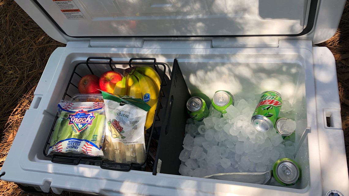 Cooler filled with fresh fruits, snacks, and drinks on ice