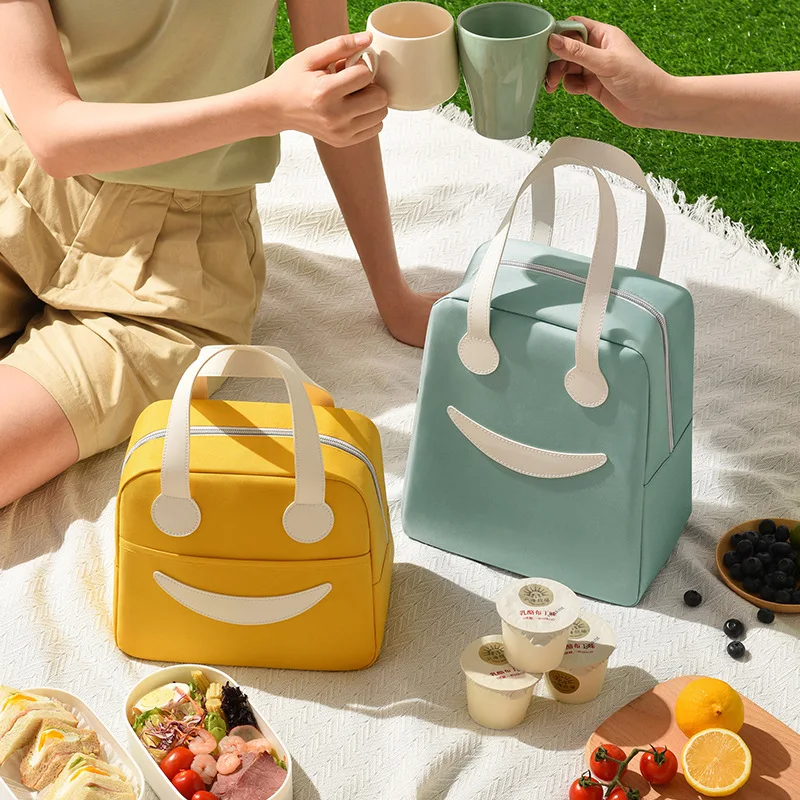 Yellow and blue insulated bags on a picnic setting, with food and drinks