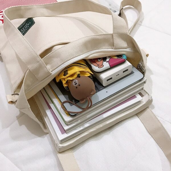 Open tote bag filled with books, gadgets, and accessories