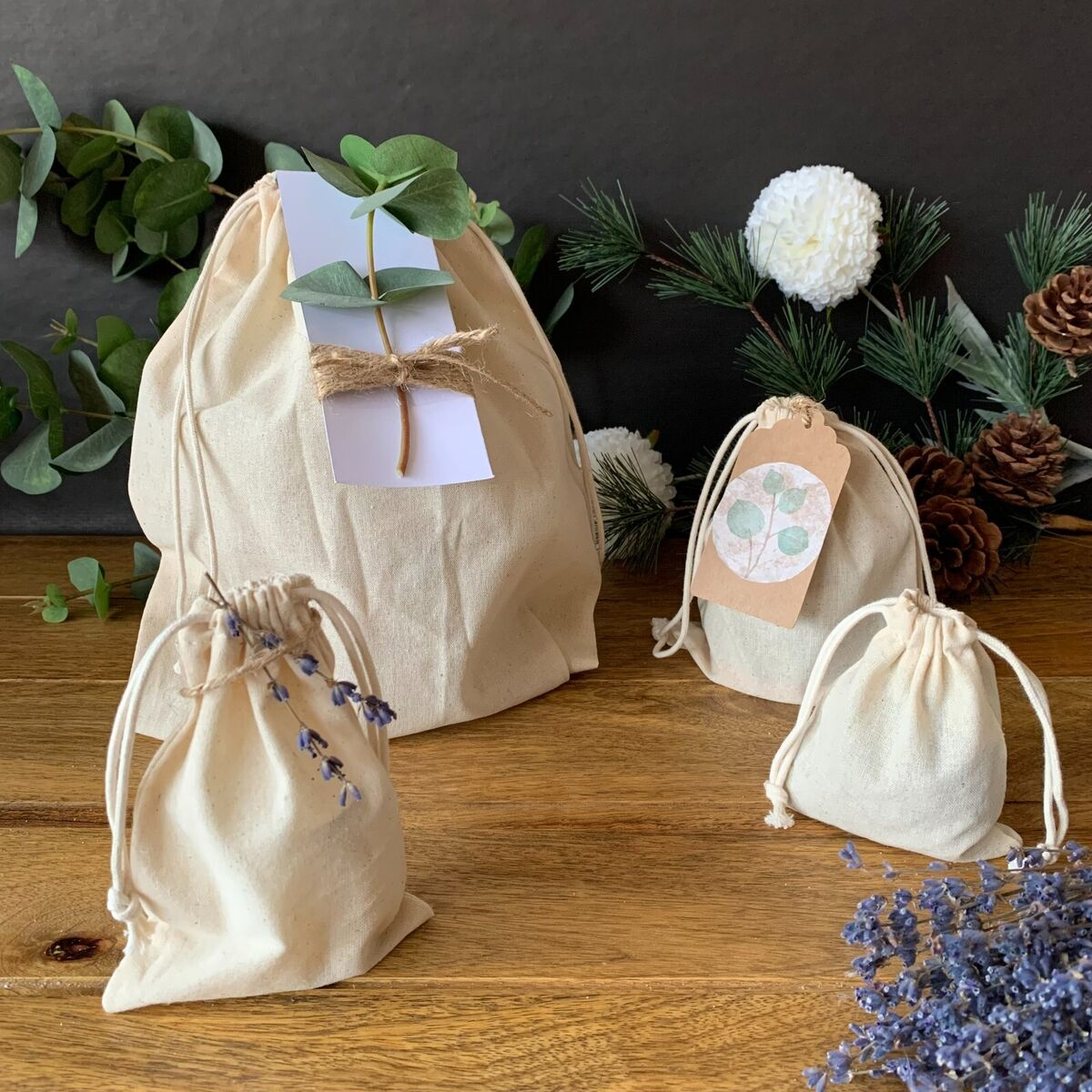 Eco-friendly drawstring pouches with natural decorations on a wooden table