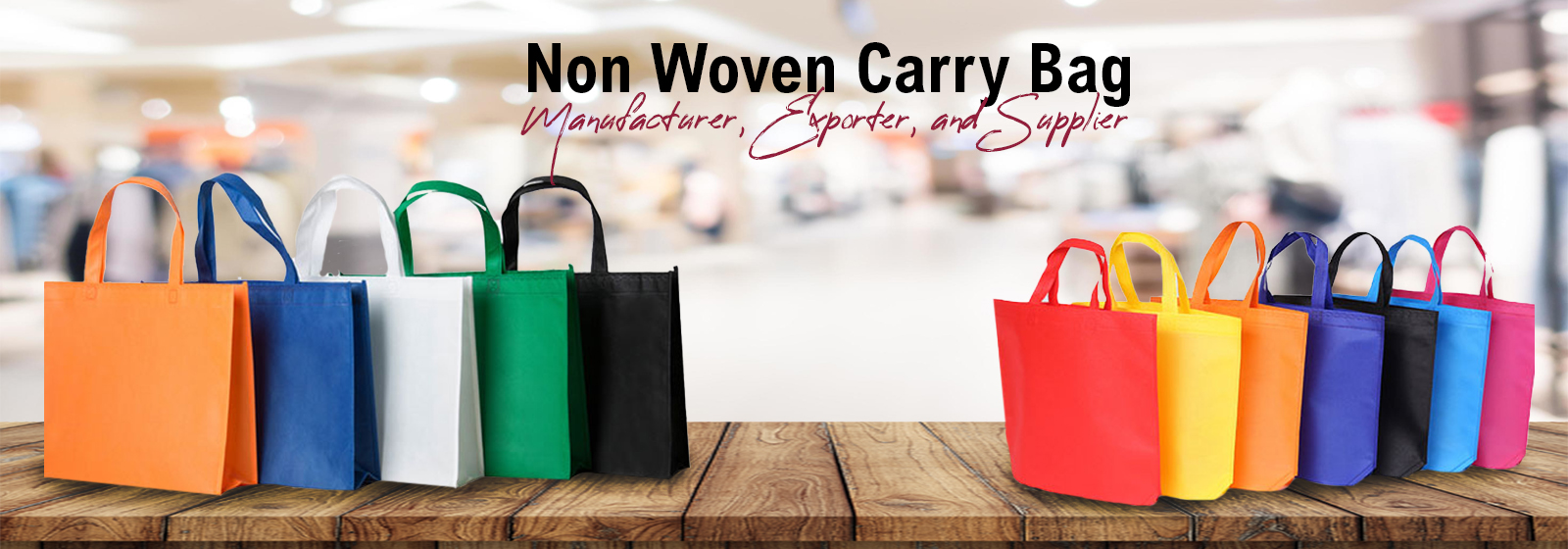 Colorful non-woven carry bags on wooden table with blurred background