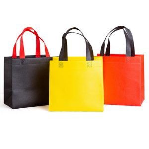 Colorful non-woven tote bags in black, yellow, and red