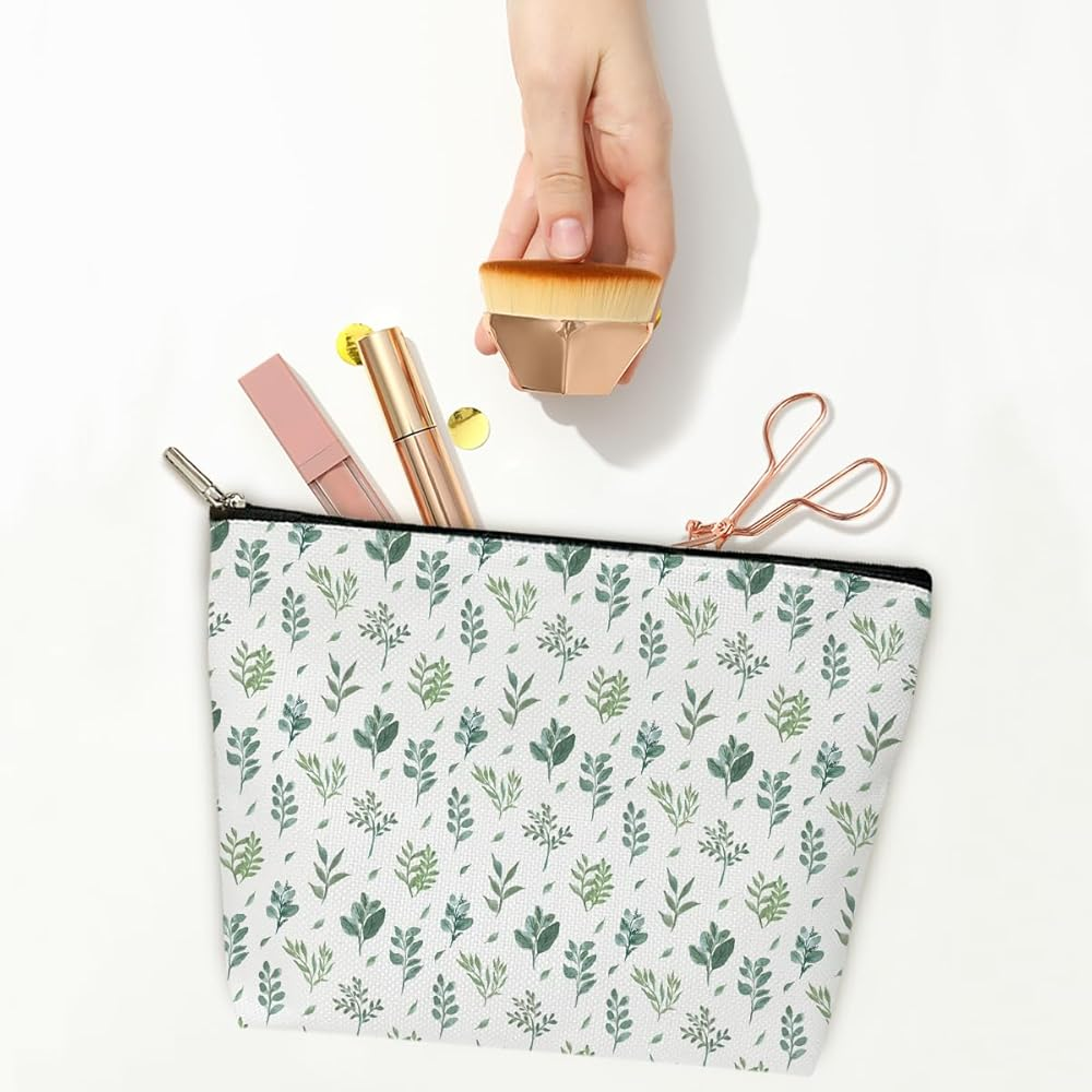 White makeup bag with green leaf pattern, holding makeup items