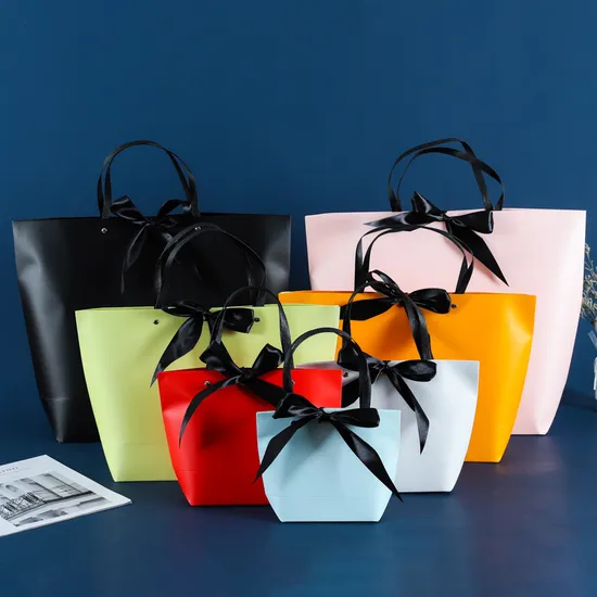 Colorful non-woven gift bags with black ribbon bows