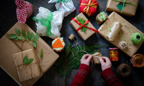 Eco-friendly gift wrapping materials, hands tying twine around a gift