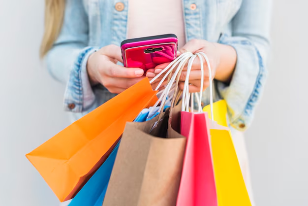 Woman holding colorful shopping bags and a smartphone