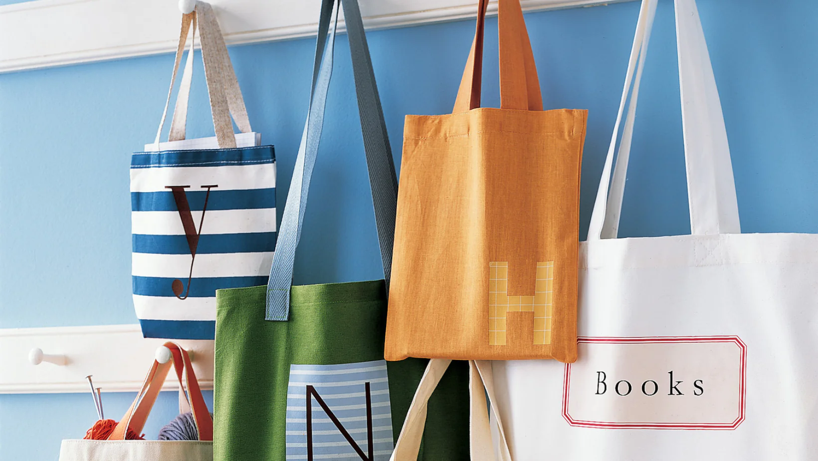 Colorful reusable tote bags hanging on hooks