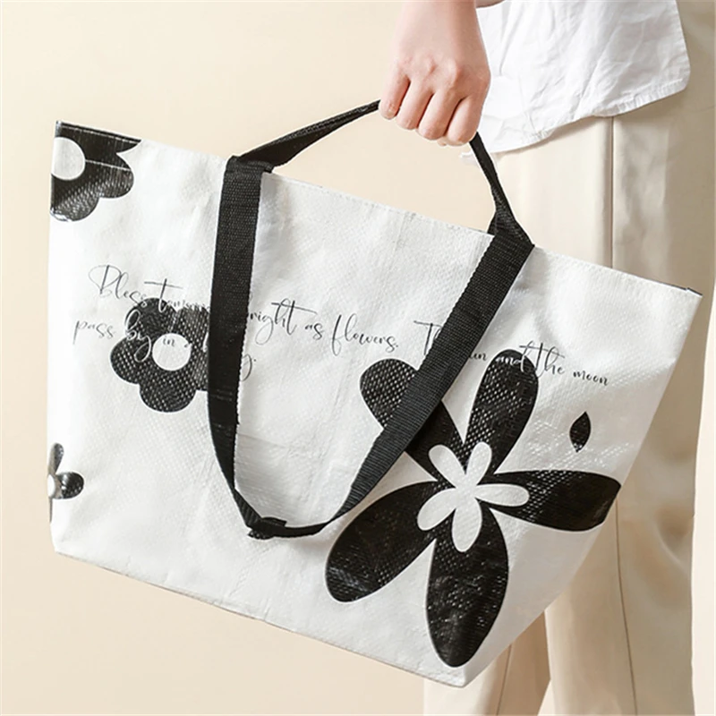 Non-woven handbag with flower pattern, white background, and black handles