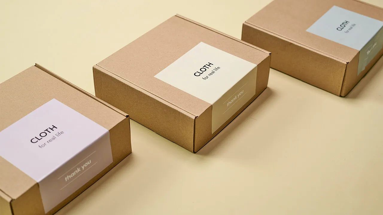 Three kraft packaging boxes labeled 'CLOTH for real life'