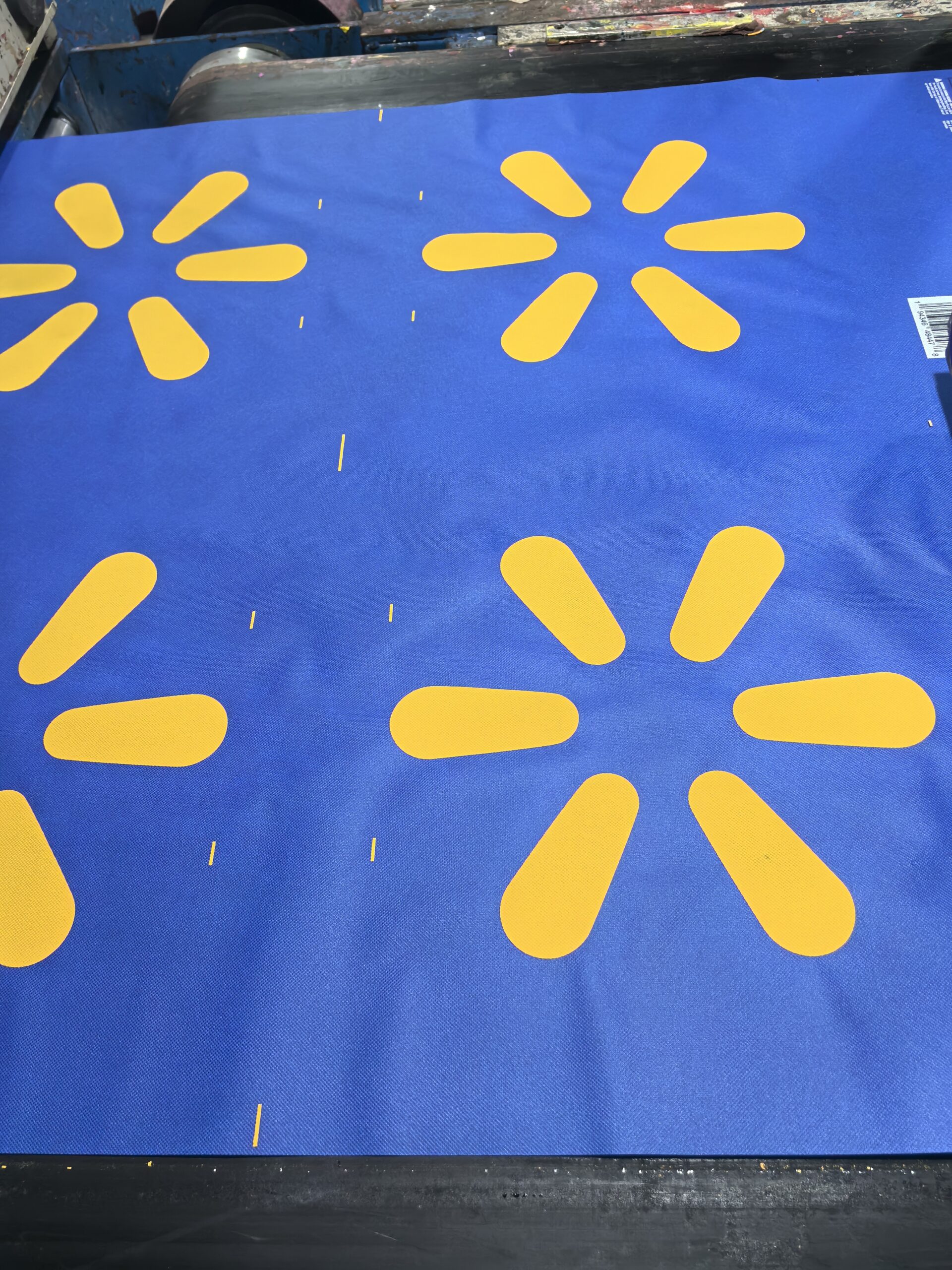 Blue non-woven fabric with yellow printed icons on production machine