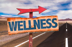 Weathered road sign with arrow and the word WELLNESS