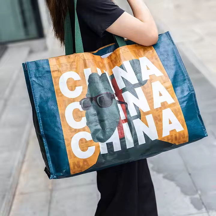 Large blue laminated PP woven bag with "maxi" logo and slogan