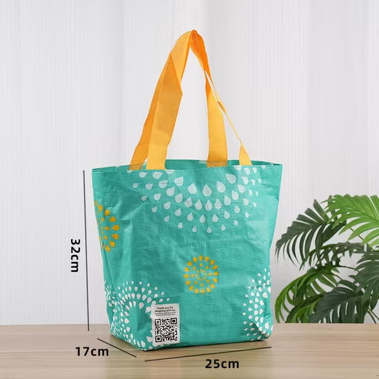 Teal non-woven bag with yellow handles and white-orange floral print