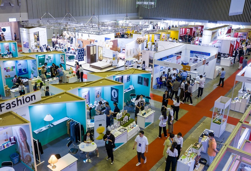 Visitors entering international trade show with staff assisting at gates