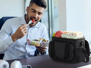 Man eating lunch with a black insulated take-out bag on table