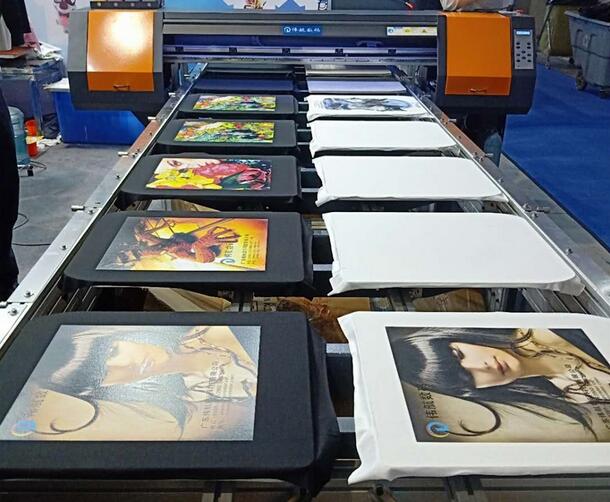 Direct-to-garment printer printing colorful designs on fabric bags