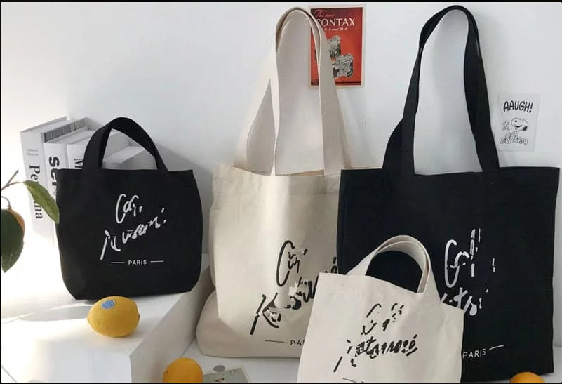 Black and beige canvas tote bags with artistic Paris-themed text prints