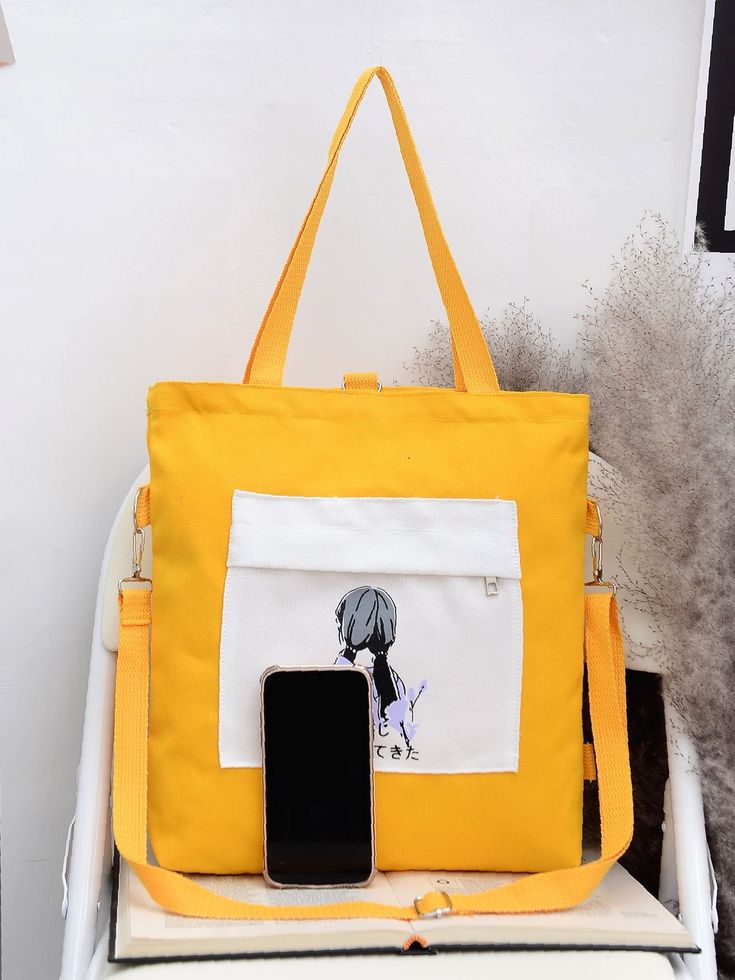 Yellow canvas shoulder bag with printed pocket and adjustable strap