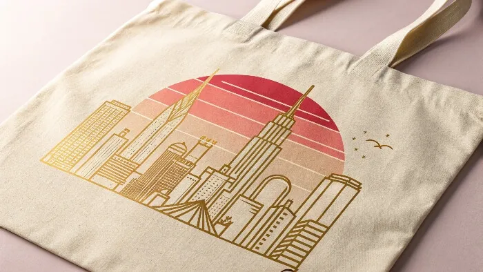 Beige tote bag with golden city skyline and red sunset graphic
