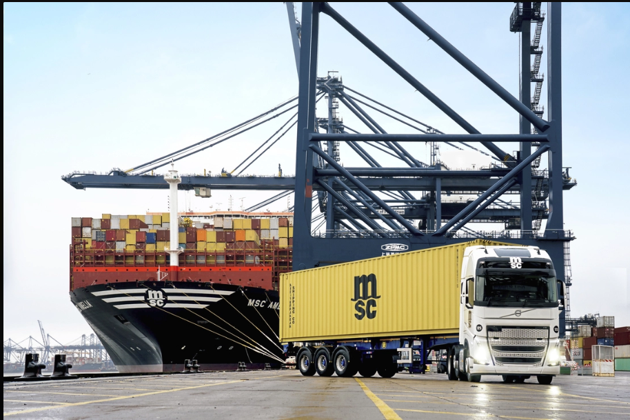 MSC shipping container truck and cargo ship at busy port terminal