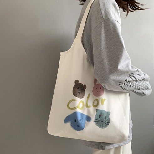 Girl carrying a white tote bag with colorful animal faces and text