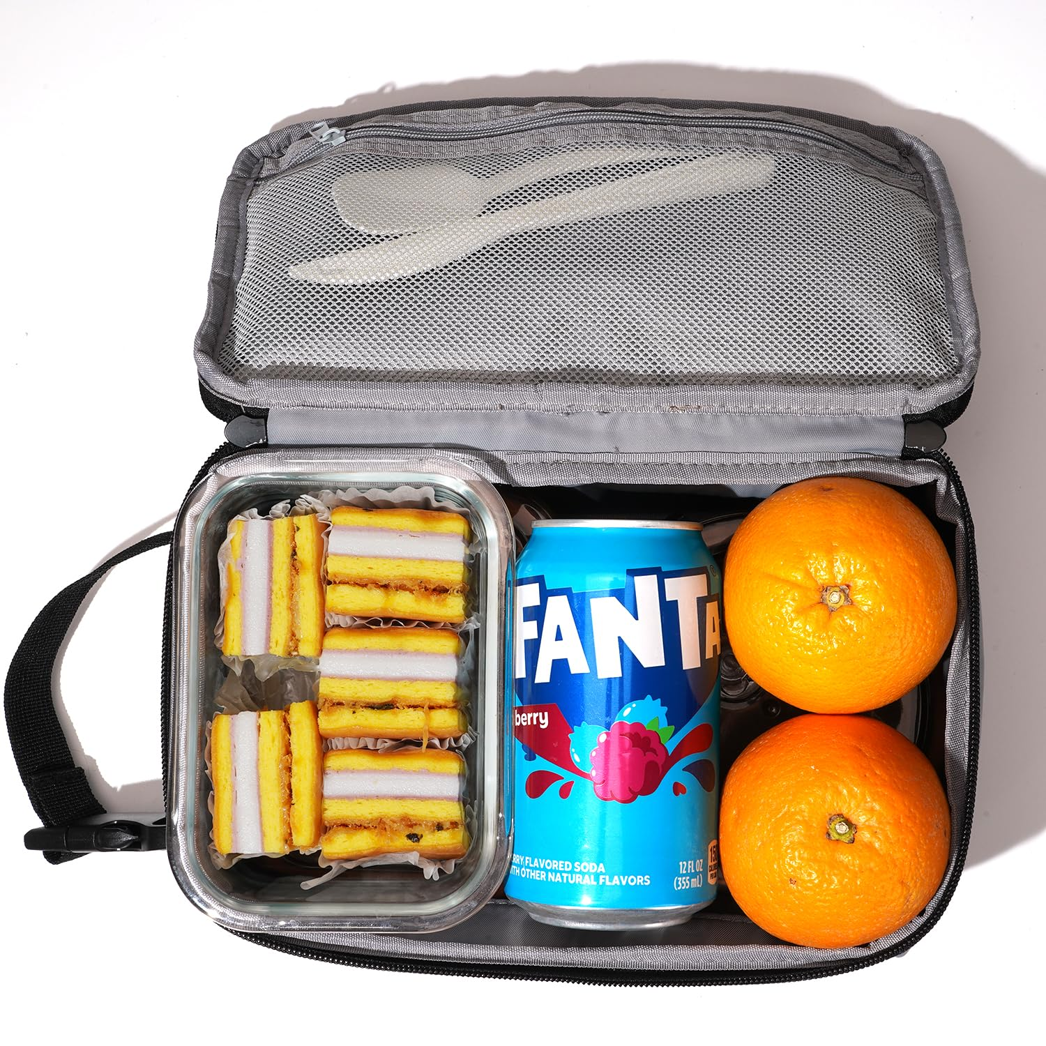 Lunch cooler bag with Fanta, sandwiches, and oranges