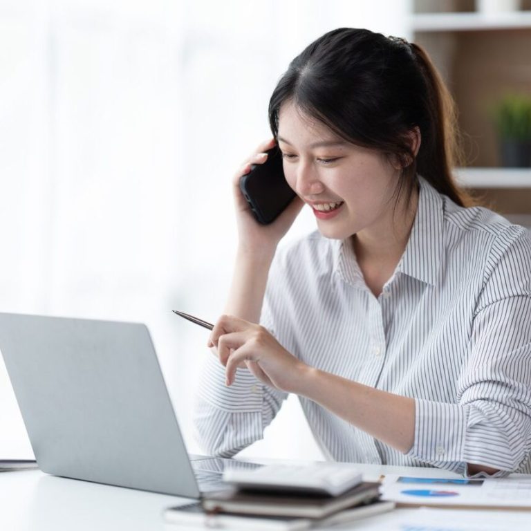 asian-businesswoman-in-formal-suit-in-office-happy-and-cheerful-during-using-smartphone-and-working-.jpg